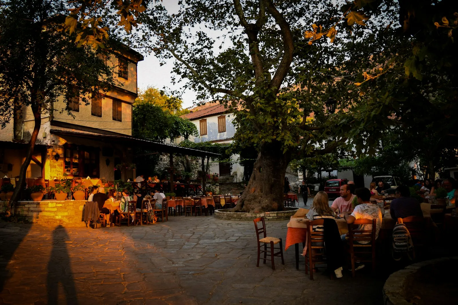 a group of people sitting at tables in a courtyard